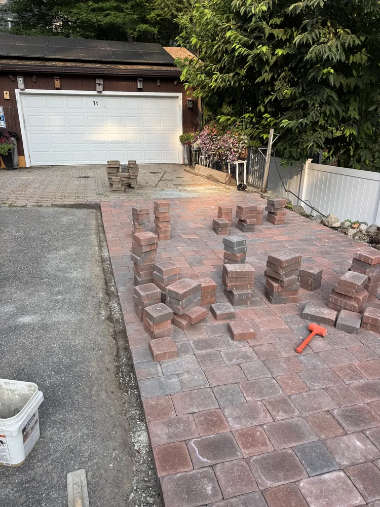 Brick pavers being installed beside a driveway