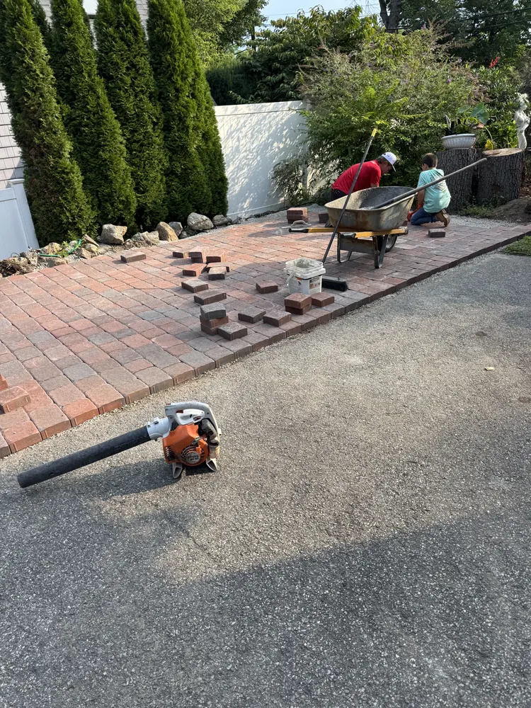 Crew installing brick pavers