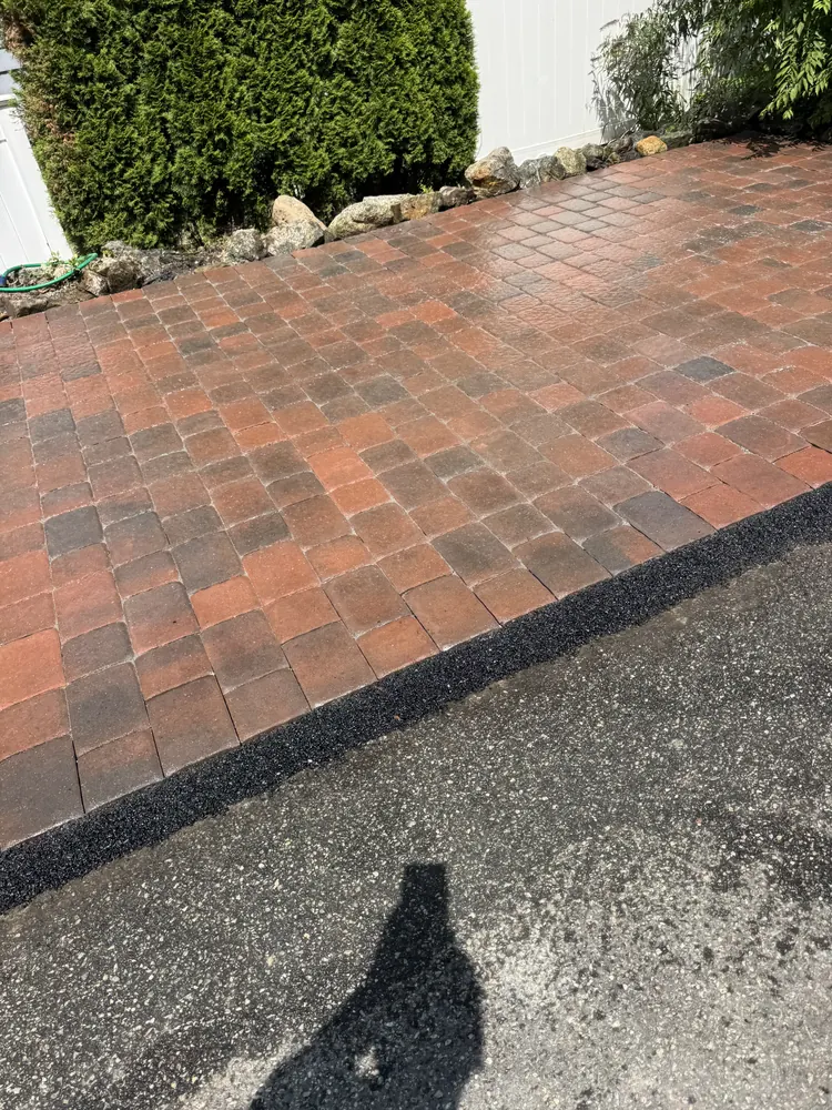Completed brick paver edge beside asphalt